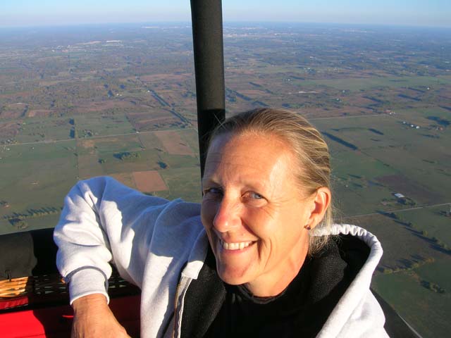 Amy floats above the neighborhood in a hot air balloon.